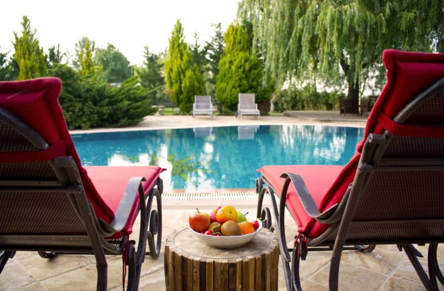 an outdoor swimming pool and two chairs